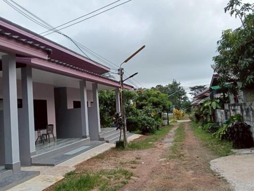 a house with a dirt road in front of it at เจ๊สวนบังกะโล in Ban Dan Mai