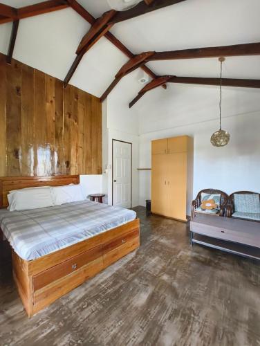 a bedroom with a large bed and wooden walls at Casa del mar house in Paje