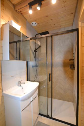 a bathroom with a shower and a sink at Całoroczny, drewniany domek przy lesie in Prażmów