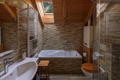 a bathroom with a tub and a toilet and a sink at Hanga Vendégház Parád in Parád