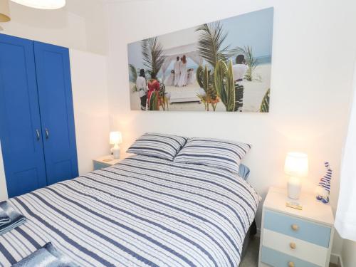 1 dormitorio con cama de rayas y una foto en la pared en The Sanctuary, en Richmond