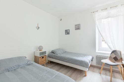 a bedroom with two beds and a chair and a window at maison Amboise in Limeray