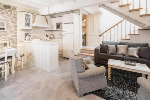 a kitchen and living room with a couch and a table at Casa de Carmen in Corcubión
