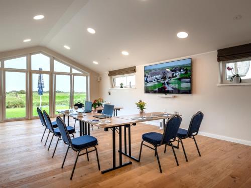 胡苏姆Nordsee-Hotel Arlau-Schleuse的有一张大桌子和几把椅子的餐厅