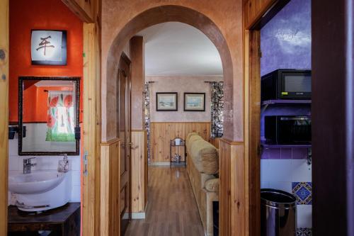 サン・ファン・デ・アスナルファラチェにあるSan Juan Bien Comunicadoの洗面台付きバスルームへと続くアーチ道