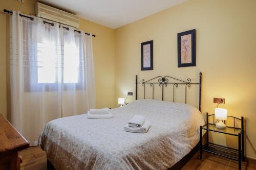 サン・ファン・デ・アスナルファラチェにあるSan Juan Bien Comunicadoのベッドとタオル2枚のある寝室