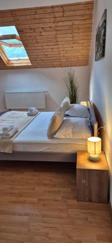 een slaapkamer met een groot bed en een dakraam bij Rare Forest Retreat & Spa in Bran