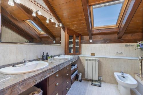 Un baño con dos lavabos y un inodoro. en Un duplex con encanto, en Jaca