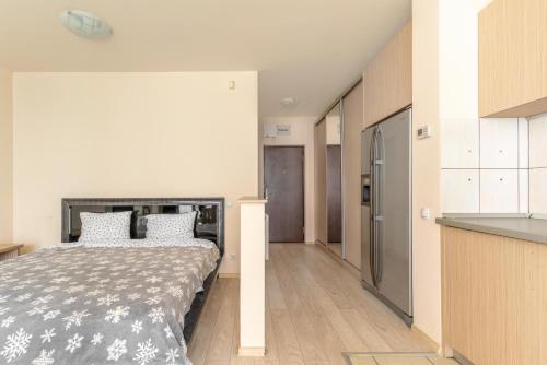 een slaapkamer met een bed en een keuken bij City Oasis Studio in Oradea