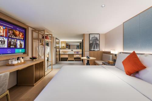 a hotel room with a large bed and a television at Manxin Hotel Beijing Lama Temple in Beijing