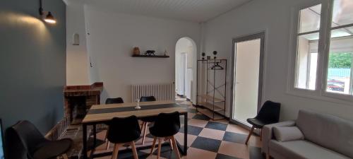 ein Wohnzimmer mit Tisch und Stühlen in der Unterkunft Maison charmante avec patio ! in Bourges