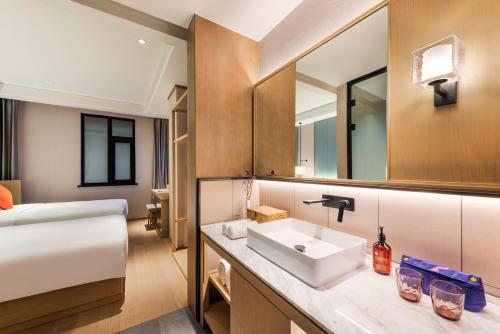 a bathroom with a sink and a bed at Manxin Hotel Beijing Lama Temple in Beijing
