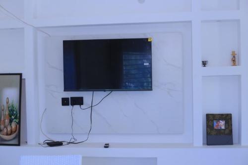 a flat screen tv hanging on a white wall at McMillan Hotel in Entebbe