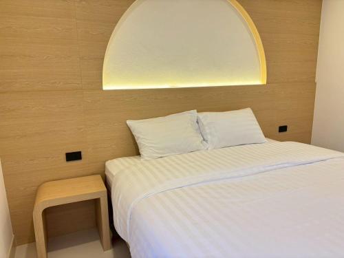 a small bedroom with a bed and a stool at Luna Resident in Ban Bang Phai