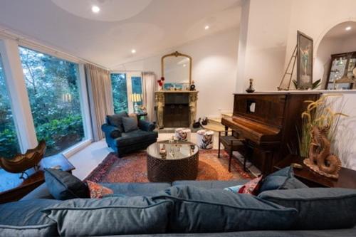 a living room with a blue couch and a piano at Idaway Retreat in Olinda