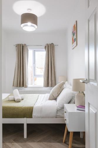 a white bedroom with a bed and a window at Luxurious 3 Bedroom Home in Belfasts Trendy Lisburn Road Sleeps 6 Modern & Spacious in Belfast