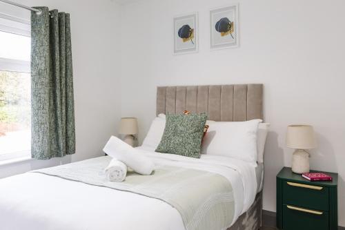 a bedroom with a bed with white sheets and a window at Luxurious 3 Bedroom Home in Belfasts Trendy Lisburn Road Sleeps 6 Modern & Spacious in Belfast