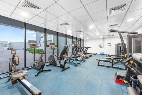 a gym with several treadmills and cardio machines at Free housekeeping visits during your stay - StayShort - Jebel Ali Sleeps 2 with a Beautiful Swimming Pool in Dubai