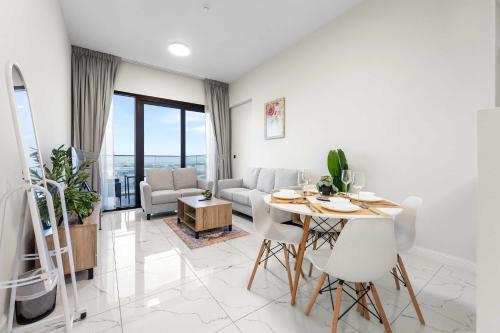 a living room with a table and a couch at Free housekeeping visits during your stay - StayShort - Jebel Ali Sleeps 2 with a Beautiful Swimming Pool in Dubai