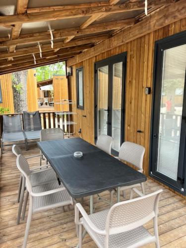 een zwarte tafel en stoelen op een houten terras bij Best Holiday Port Grimaud in Grimaud