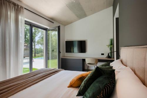Schlafzimmer mit einem Bett, einem TV und einem Fenster in der Unterkunft Villa Vista Verde in Majkusi
