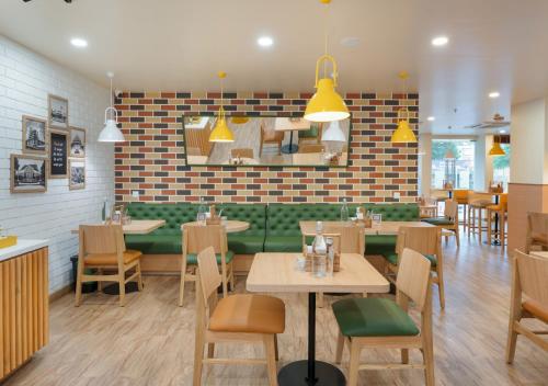 a restaurant with tables and chairs and a brick wall at Bloom Hotel - Whitefield in Bangalore