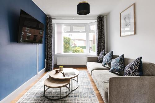 a living room with a couch and a table at Luxurious 3 Bedroom Home in Belfasts Trendy Lisburn Road Sleeps 6 Modern & Spacious in Belfast