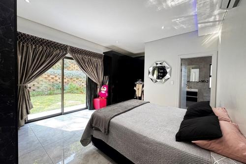 a bedroom with a large bed and a large window at The Coastal Charm Villa in Ballito