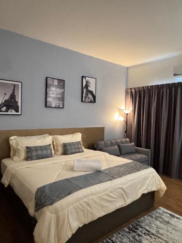 a bedroom with a large bed and a couch at WANida Suite At Al Waqaf Resident Bandar Baru Tunjung in Kota Bharu