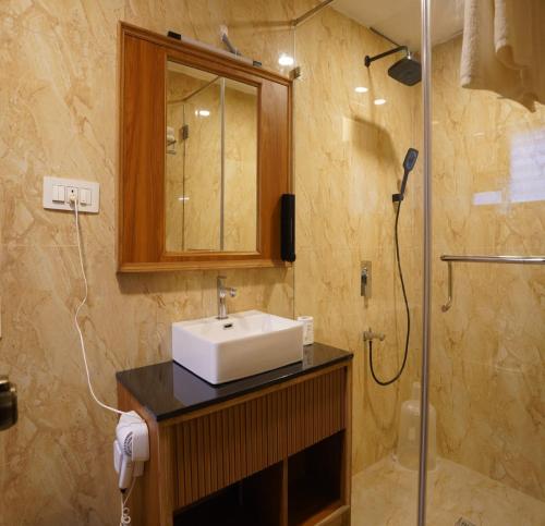 Un baño con lavabo y ducha en Thappa Garden, en Kāraikkudi