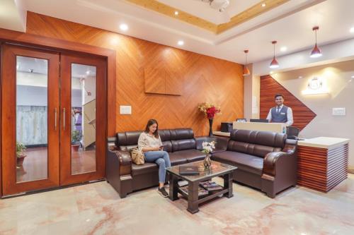 a woman sitting on a couch in a waiting room at FabHotel Grand Arya in Patna