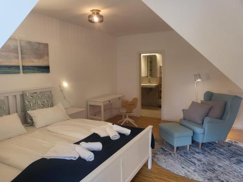 a bedroom with a bed and a blue chair at Böhler Haubarg Böhler Stuv 7 in Böhl
