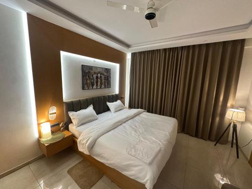 a bedroom with a large bed with white sheets at Amara heaven in Lucknow