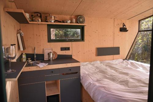 una pequeña cocina con una cama en una casa pequeña en Sleep Space 1 - Green&Tiny Spot Osterwieck Birkenmühle, en Osterwieck