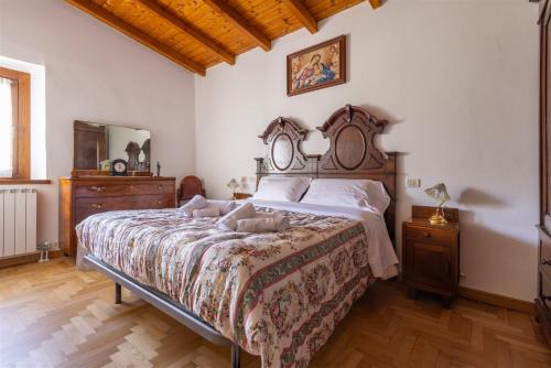 a bedroom with a large bed and a wooden ceiling at IseoLakeRental - Chalet Giulia in Sovere