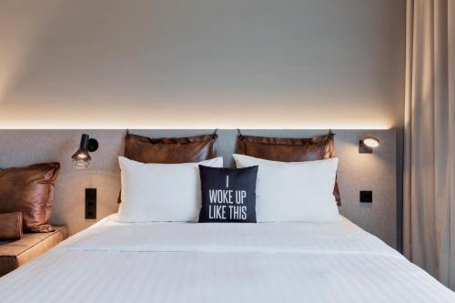 a bed with a pillow that says i woke up like this at Moxy Zurich in Zürich