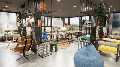 um restaurante com cadeiras e mesas e uma sala com mesas em Moxy Zurich em Zurique