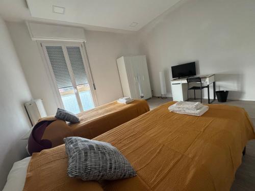 a room with two beds and a television in it at Da Vinci Apartment in Lavezzola