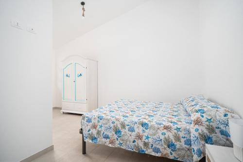 een slaapkamer met een bed en een kleine kast bij Girasole in La Caletta