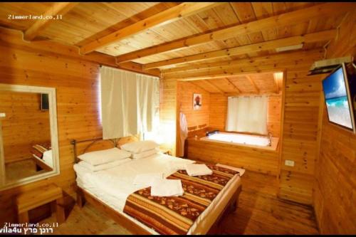 Postel nebo postele na pokoji v ubytování נופים בלבן - בקתה עם אמבט ספא מלבני ענק ובריכה פרטית