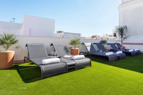eine Sitzreihe auf einem Rasen in der Unterkunft Genteel Home Patrocinio Cádiz in Cádiz