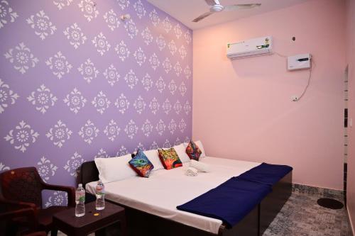 FaizābādOmkar Bhawan Home Stay的一间设有一张床和紫色墙壁的客房