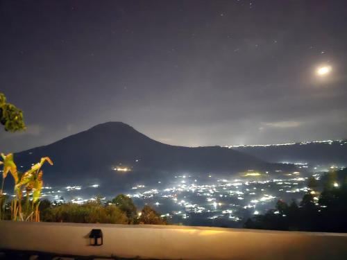 a view of a city at night with a mountain at Pinggan Chill Out Kintamani in Gretek