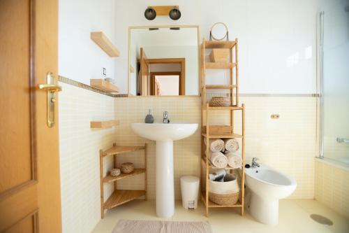 a bathroom with a sink and a mirror and a toilet at Alma Ventura House - Majanicho in Majanicho