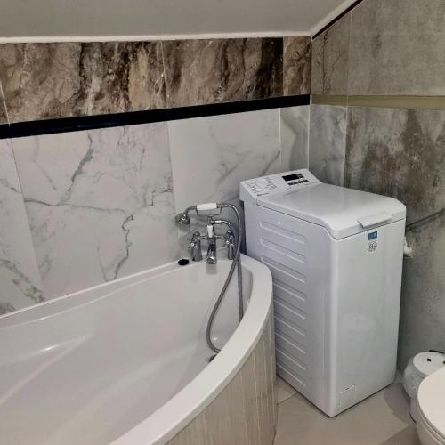 a bathroom with a tub and a toilet and a sink at Dom Kopernica 5 in Chełm