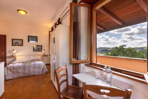 ein Zimmer mit einem Bett und einem Tisch und einem Fenster in der Unterkunft Agriturismo Le Forre del Treja (La Villa) in Civita Castellana
