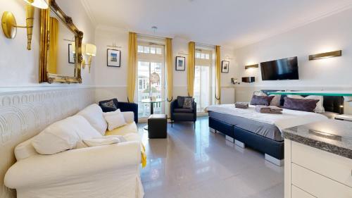 una camera d'albergo con due letti e un divano di strandnahe FeWo Villa Jugendglück 04 in Binz ID 504 a Binz