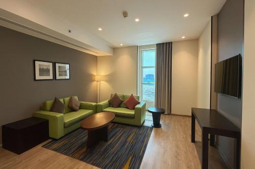 a living room with a couch and a television at Radisson Blu Plaza Jeddah in Jeddah