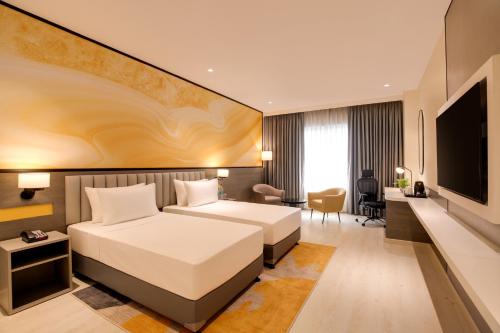 a hotel room with a bed and a television at Lemon Tree Hotel, Ranchi in Rānchī