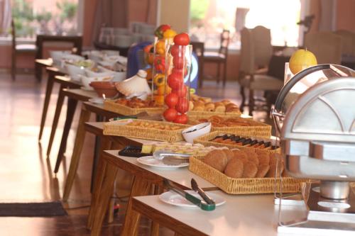 a buffet of food on tables in a restaurant at Hotel Idou Tiznit in Tiznit